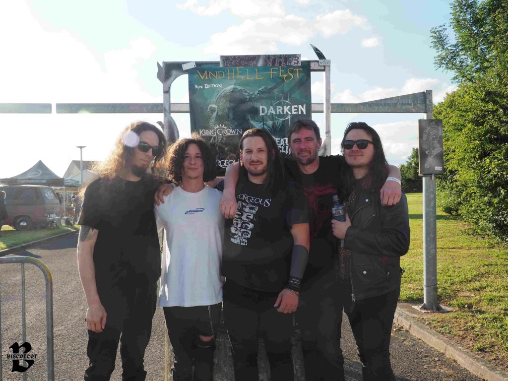 Le groupe de métal Gorgeous devant l'affiche du Vind'Hell Fest III.