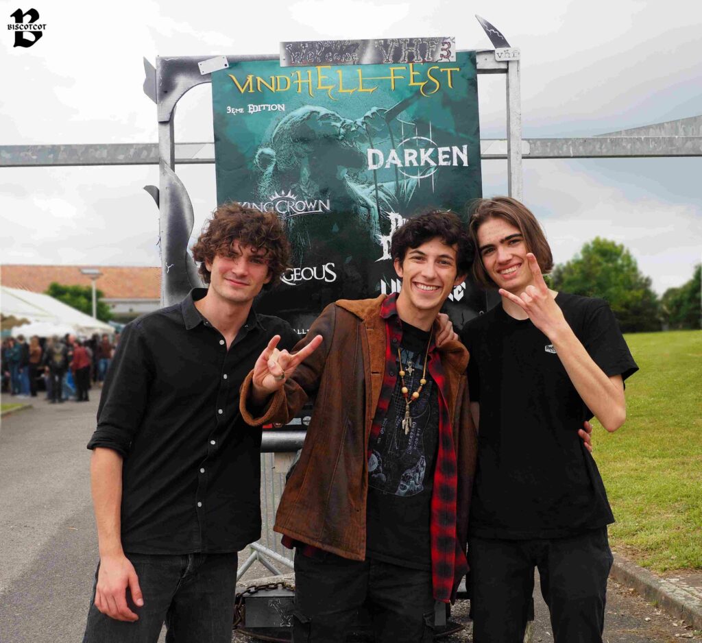 Le groupe de métal Deafsound devant l'affiche du Vind'Hell Fest III.